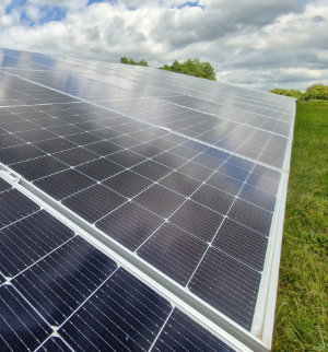 A photo of a ground-mounted solar panel array in a field